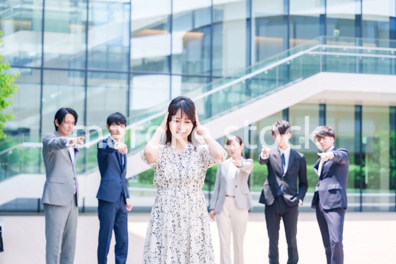 同僚に責められて頭を抱える女性のビジネスパーソン