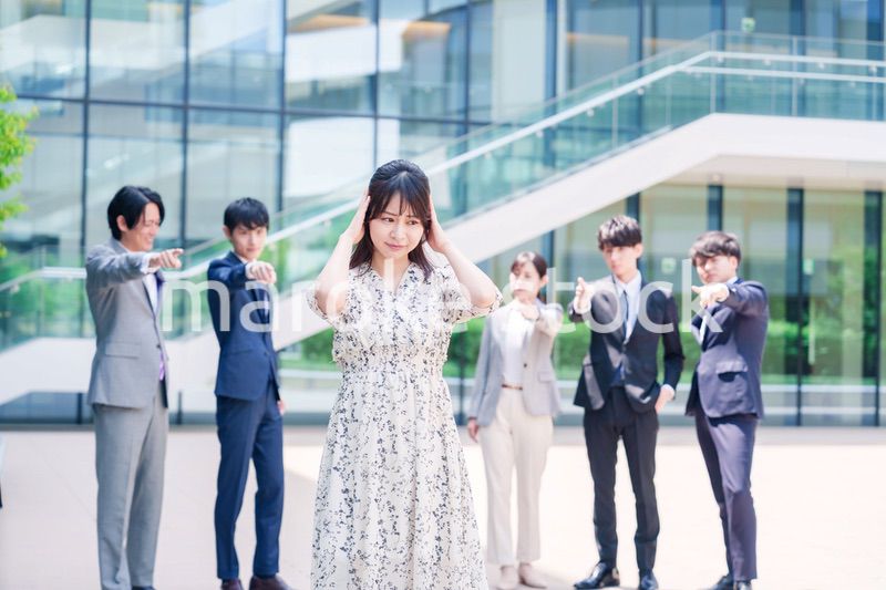 同僚に責められて頭を抱える女性のビジネスパーソン