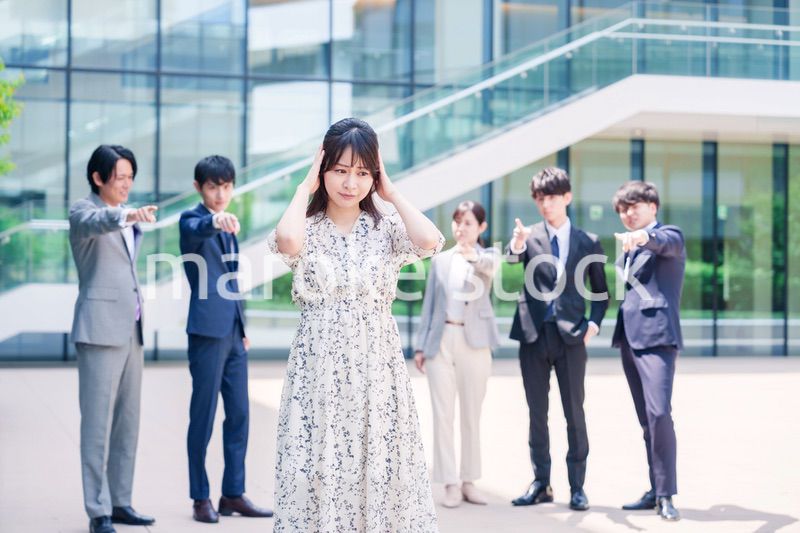 同僚に責められて頭を抱える女性のビジネスパーソン