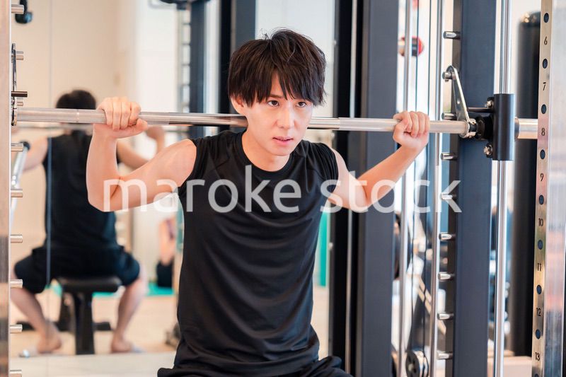 ジムで筋トレをする若い男性
