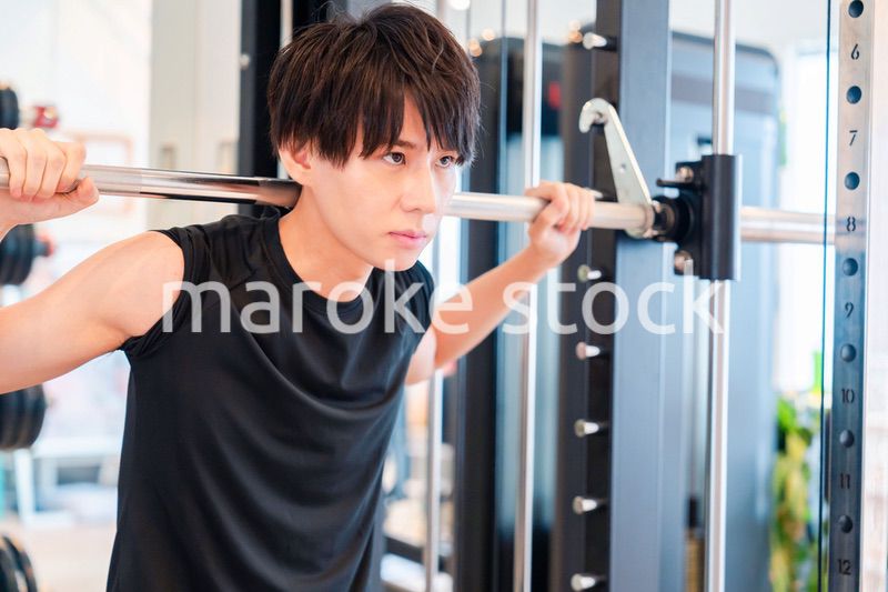 ジムで筋トレをする若い男性
