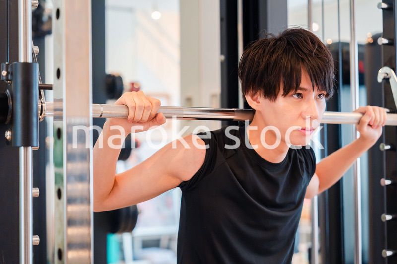 ジムで筋トレをする若い男性