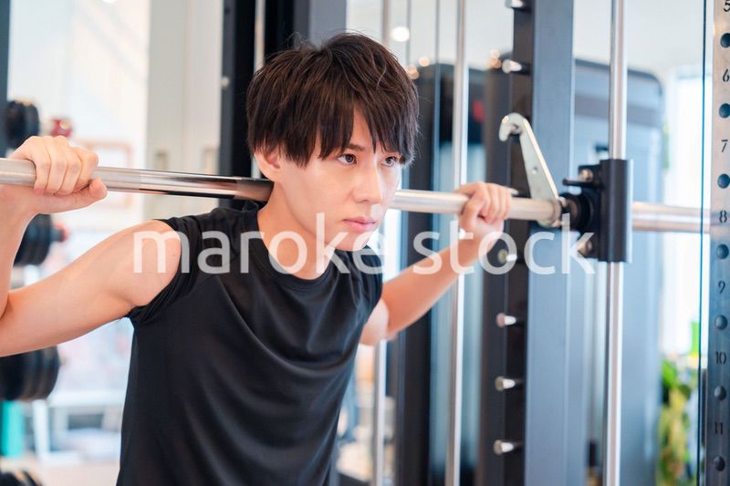 ジムで筋トレをする若い男性