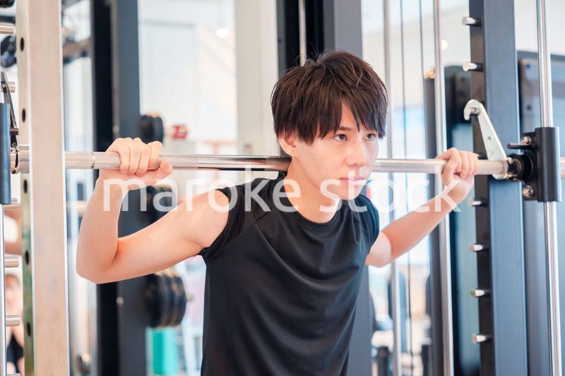 ジムで筋トレをする若い男性