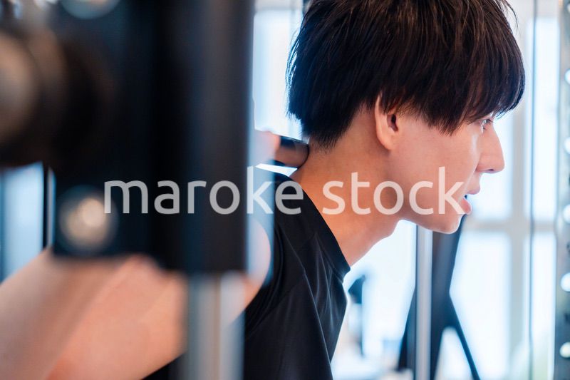ジムで筋トレをする若い男性