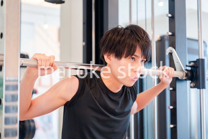 ジムで筋トレをする若い男性