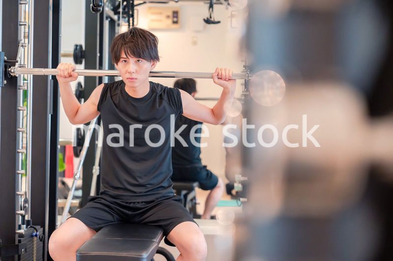 ジムで筋トレをする若い男性