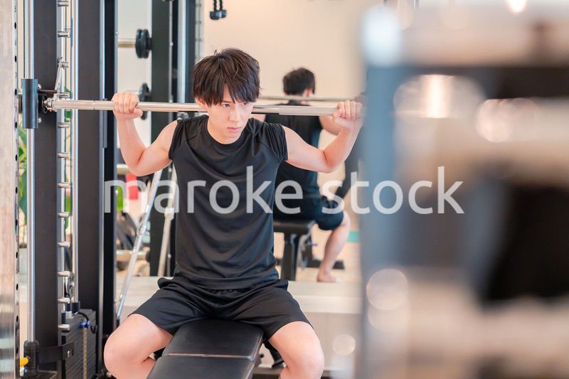 ジムで筋トレをする若い男性