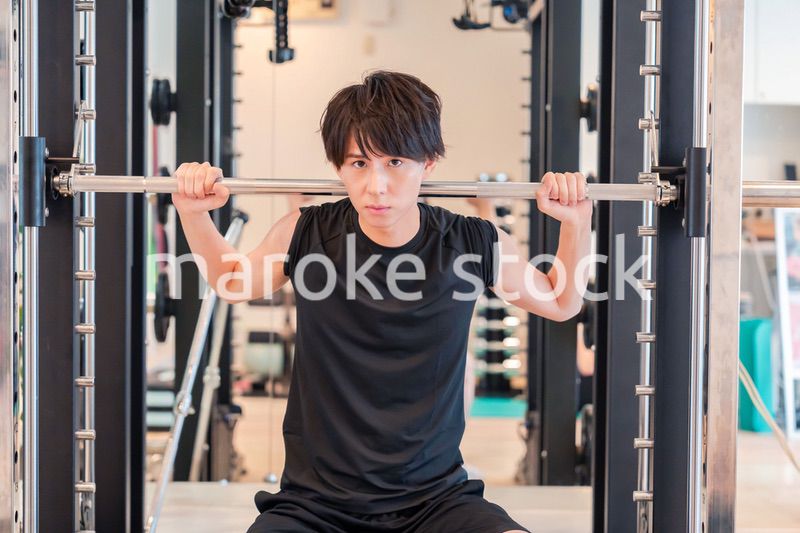 ジムで筋トレをする若い男性