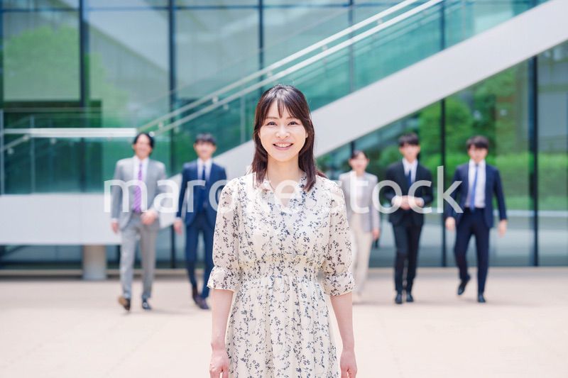オフィスの外を笑顔で歩くキャリアウーマンと同僚