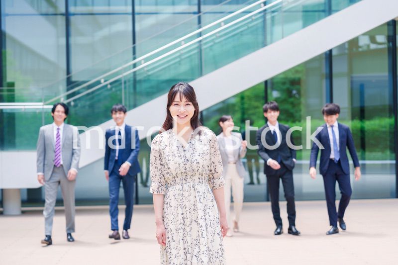 オフィスの外を笑顔で歩くキャリアウーマンと同僚