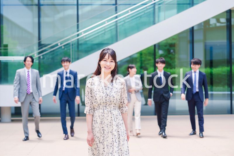 オフィスの外を笑顔で歩くキャリアウーマンと同僚