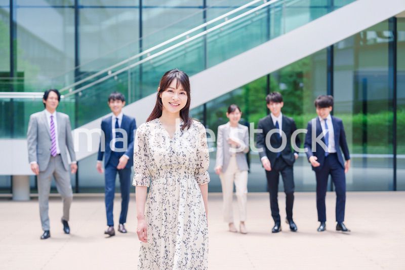 オフィスの外を笑顔で歩くキャリアウーマンと同僚