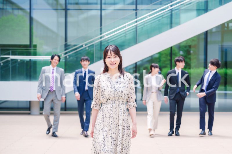 オフィスの外を笑顔で歩くキャリアウーマンと同僚