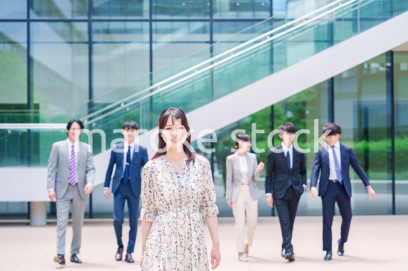 オフィスの外を笑顔で歩くキャリアウーマンと同僚