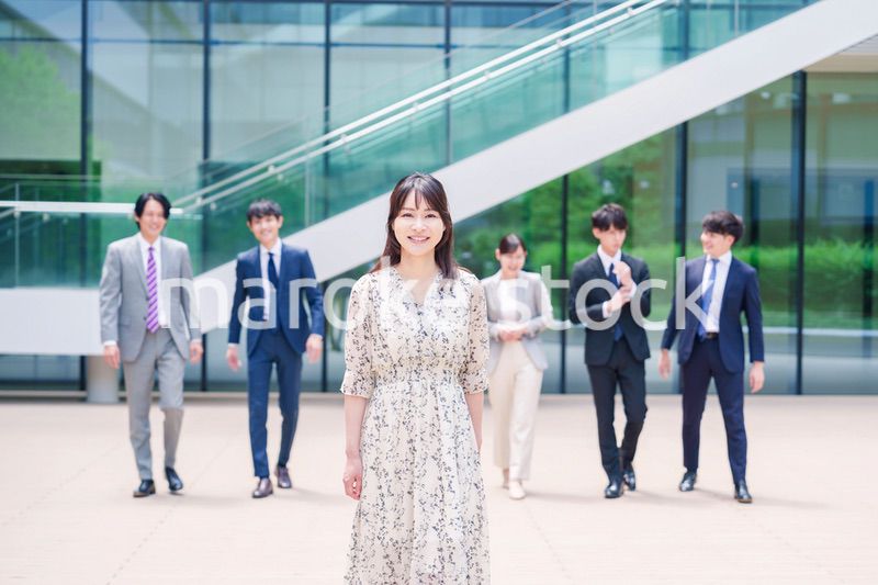 オフィスの外を笑顔で歩くキャリアウーマンと同僚