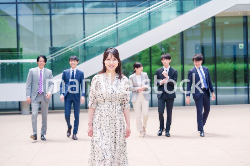 オフィスの外を笑顔で歩くキャリアウーマンと同僚