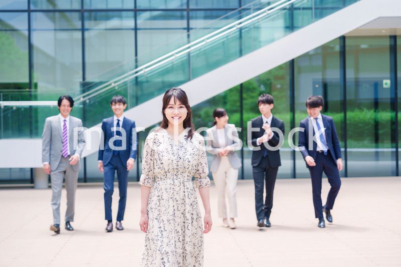 オフィスの外を笑顔で歩くキャリアウーマンと同僚