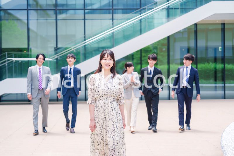 オフィスの外を笑顔で歩くキャリアウーマンと同僚