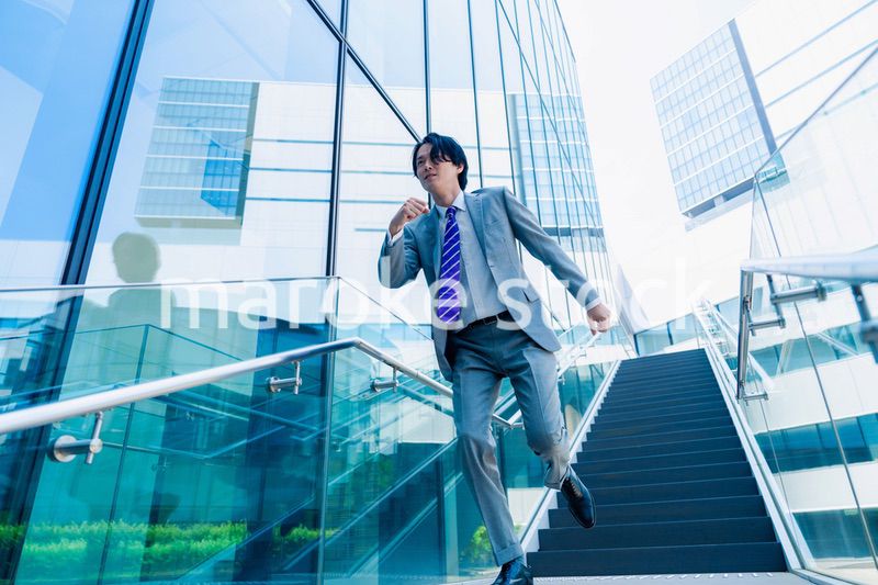 スーツを着て全力で走るビジネスマン