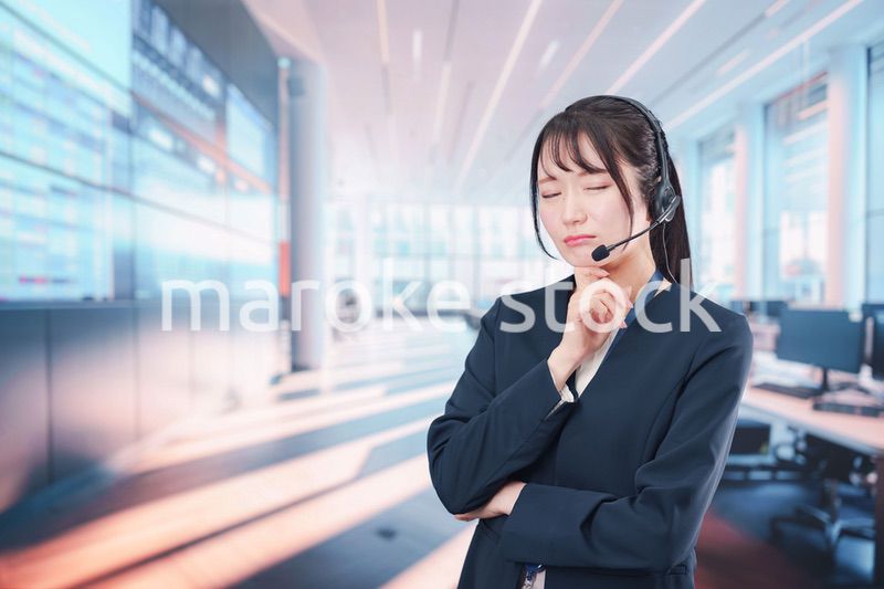 困った表情をする電話オペレータの女性