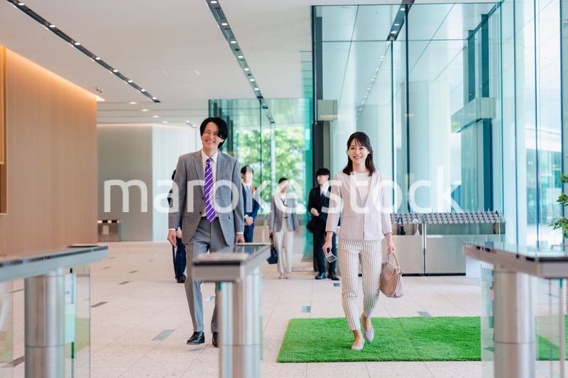オフィスのエントランスを通るビジネスパーソン