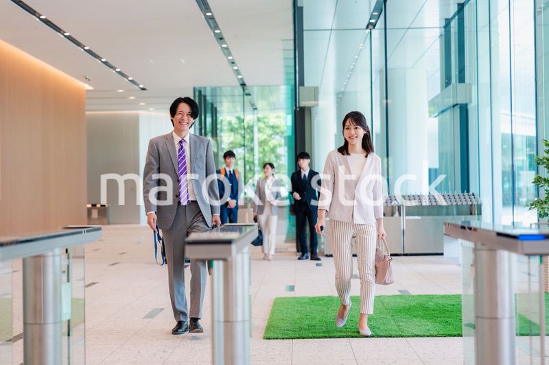 オフィスのエントランスを通るビジネスパーソン