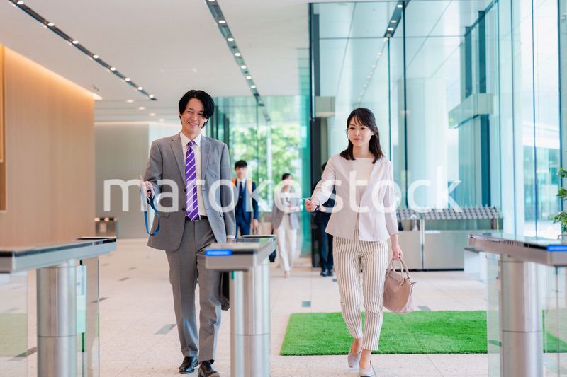 オフィスのエントランスを通るビジネスパーソン