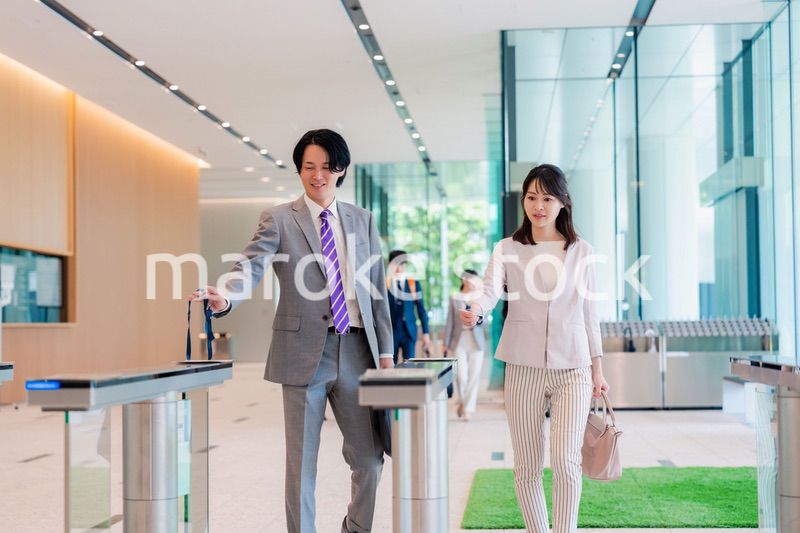 オフィスのエントランスを通るビジネスパーソン