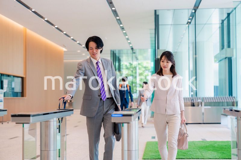 オフィスのエントランスを通るビジネスパーソン