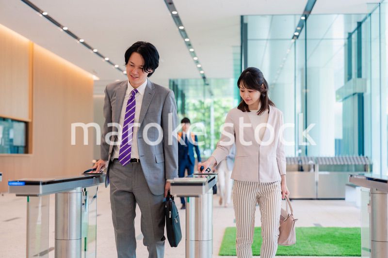 オフィスのエントランスを通るビジネスパーソン