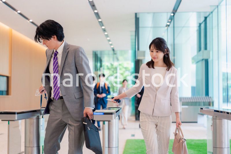 オフィスのエントランスを通るビジネスパーソン
