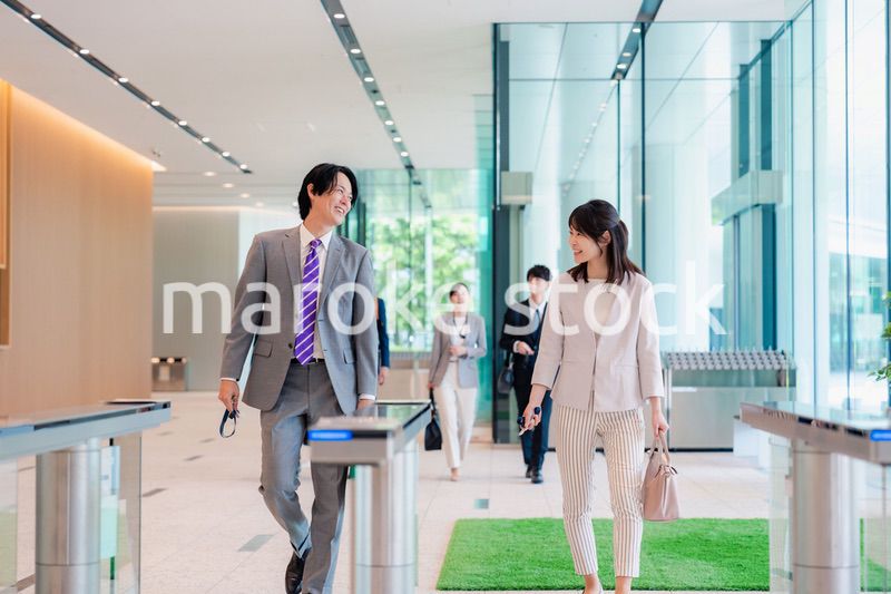 オフィスのエントランスを通るビジネスパーソン