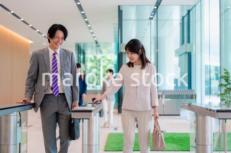 オフィスのエントランスを通るビジネスパーソン