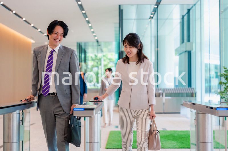 オフィスのエントランスを通るビジネスパーソン