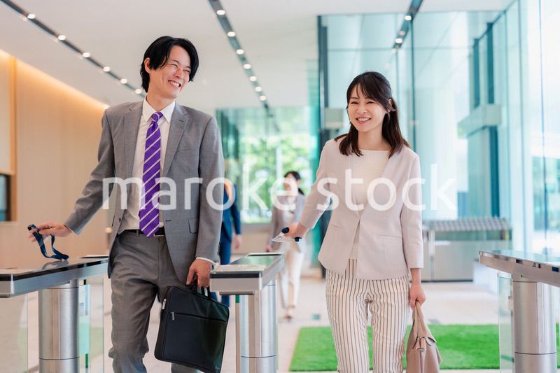 オフィスのエントランスを通るビジネスパーソン