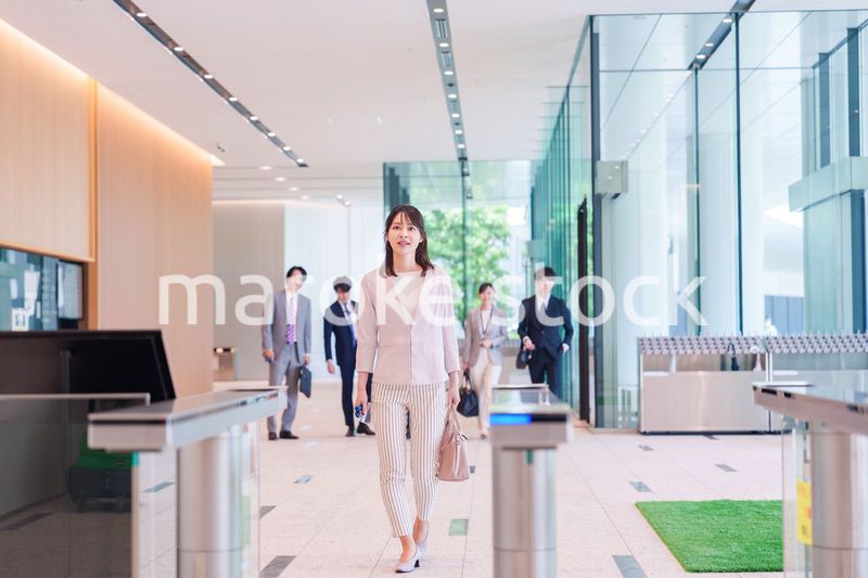 オフィスのセキュリティゲートを通るビジネスウーマン