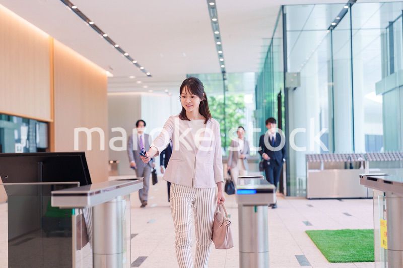 オフィスのセキュリティゲートを通るビジネスウーマン