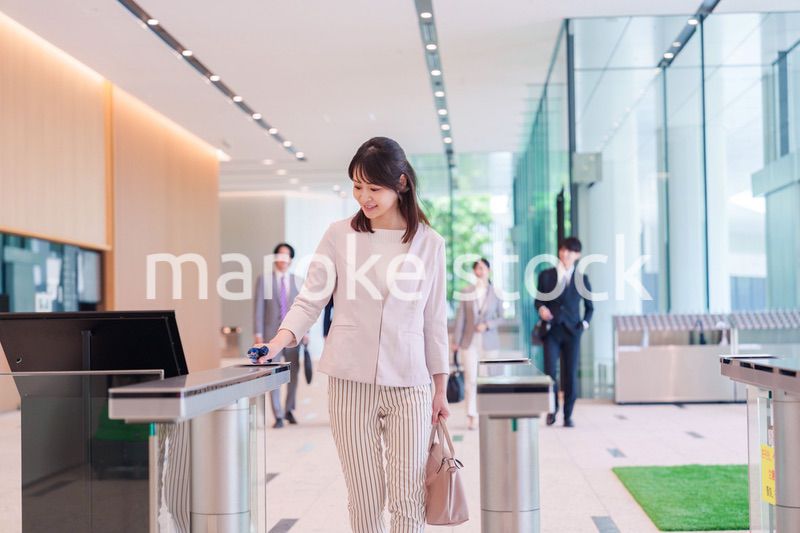 オフィスのセキュリティゲートを通るビジネスウーマン