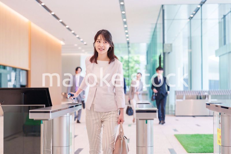 オフィスのセキュリティゲートを通るビジネスウーマン