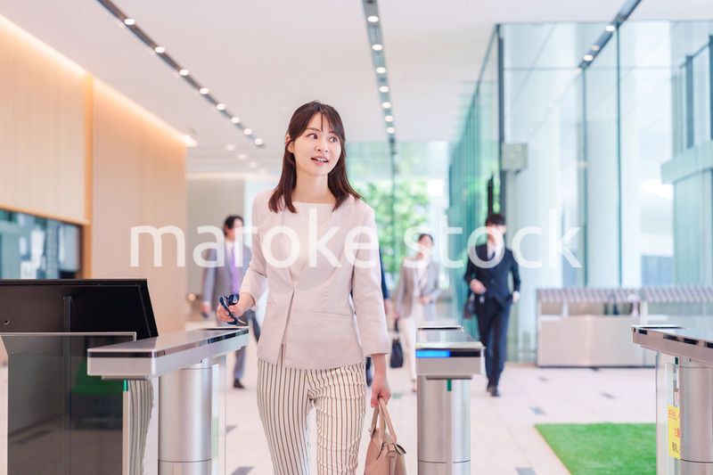 オフィスのセキュリティゲートを通るビジネスウーマン