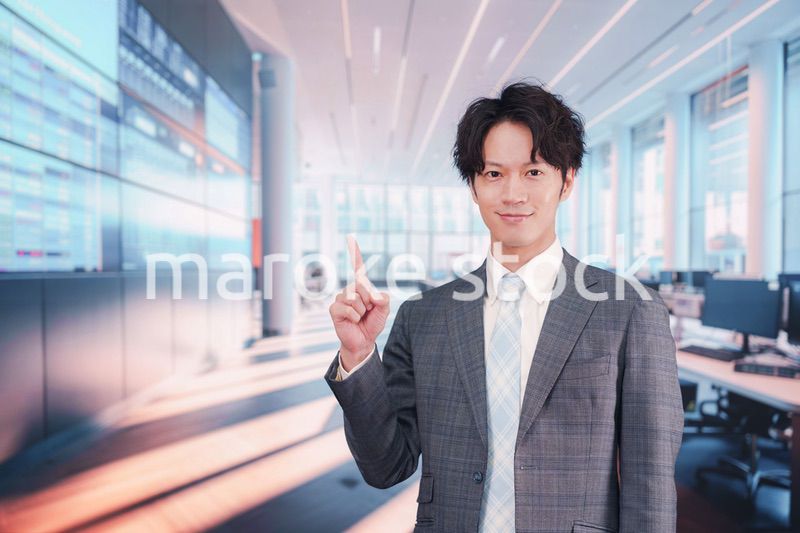 株価ボードの前に立つスーツを着たビジネスマン