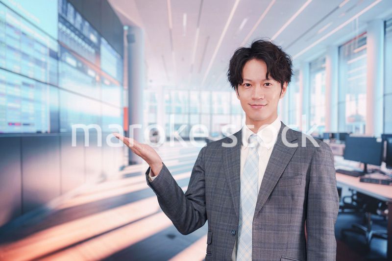 株価ボードの前に立つスーツを着たビジネスマン