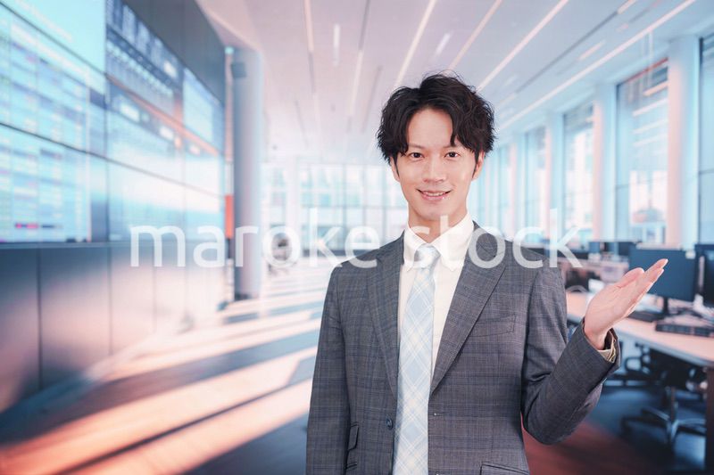 株価ボードの前に立つスーツを着たビジネスマン