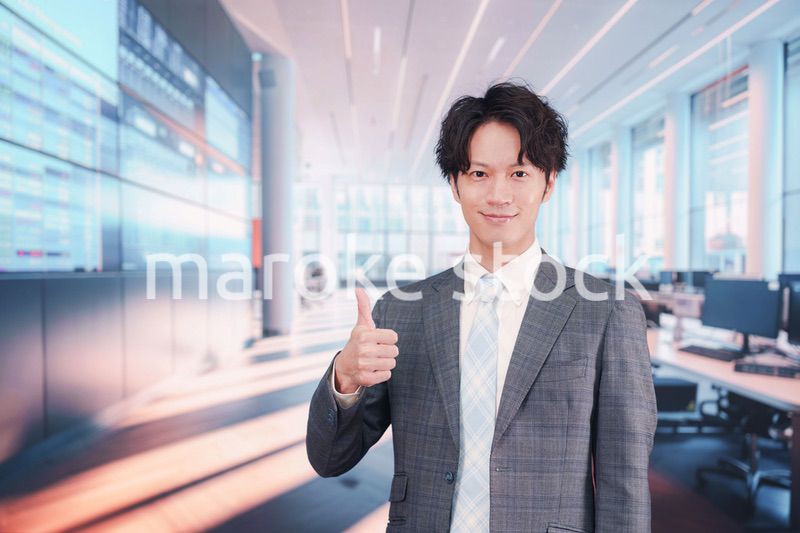 株価ボードの前に立つスーツを着たビジネスマン