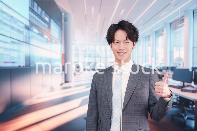 株価ボードの前に立つスーツを着たビジネスマン