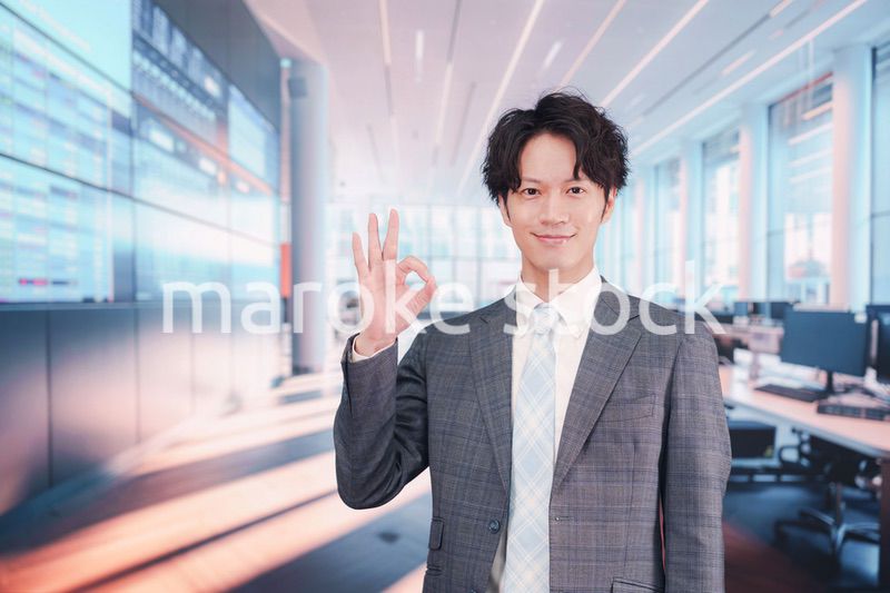 株価ボードの前に立つスーツを着たビジネスマン