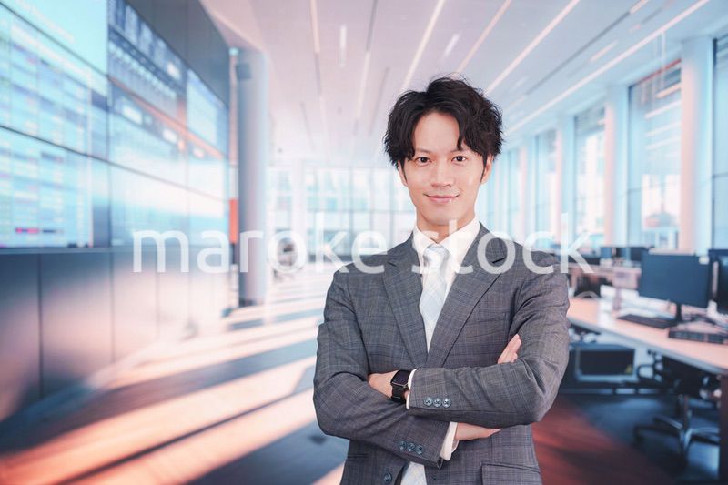 株価ボードの前に立つスーツを着たビジネスマン