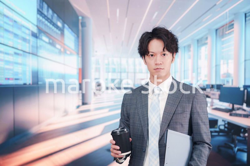 オフィスで紙カップのコーヒーを持って歩くビジネスマン