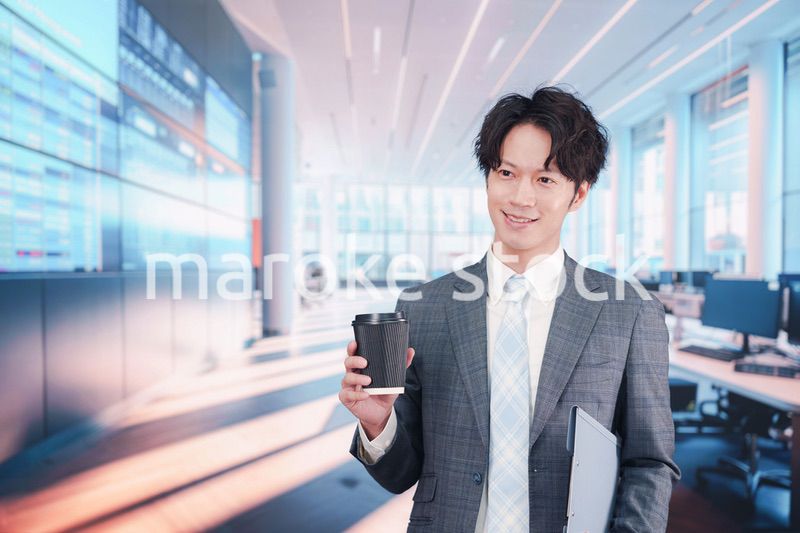 オフィスで紙カップのコーヒーを持って歩くビジネスマン